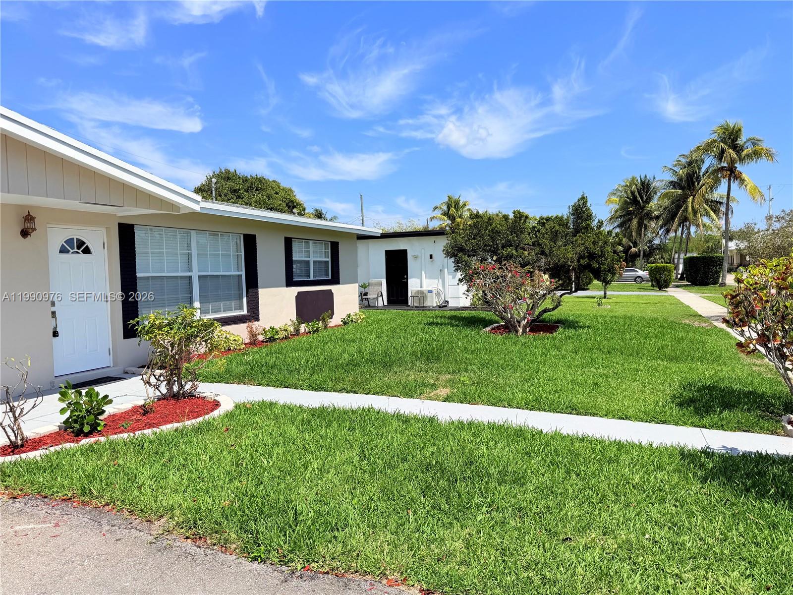 A single-story house with a white door and black window trim sits on a grassy lot — 4731 NW 11th St, Lauderhill FL 33313, LAUDERHILL, FL