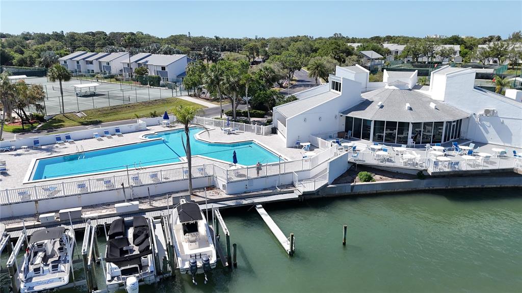An aerial view shows a swimming pool, a clubhouse, tennis courts, and boat slips — 11303 SHIPWATCH LANE UNIT 1865, LARGO, FL
