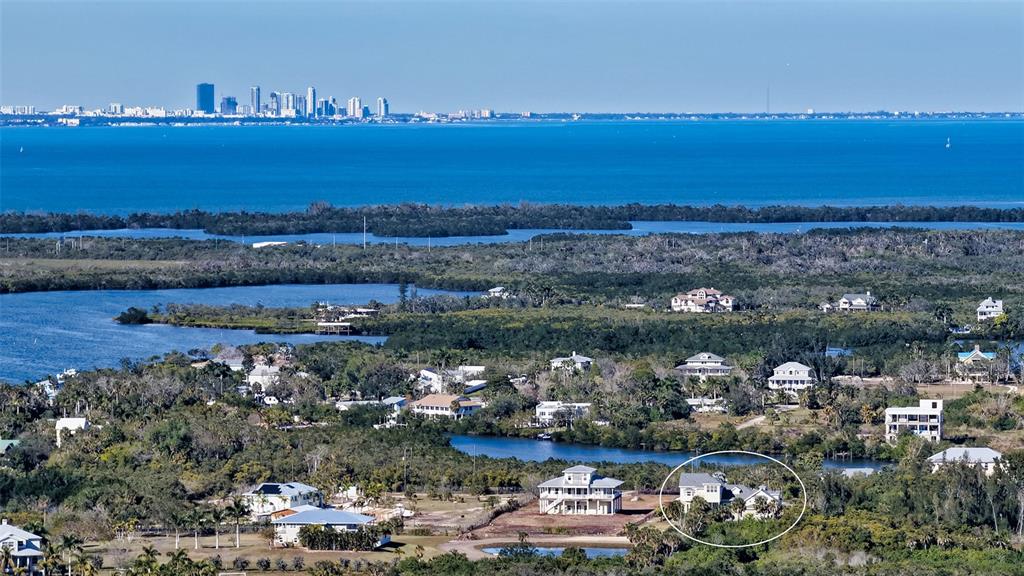An aerial view shows a coastal landscape with scattered houses, including one circled in white — 925 BAYSHORE DRIVE, TERRA CEIA, FL