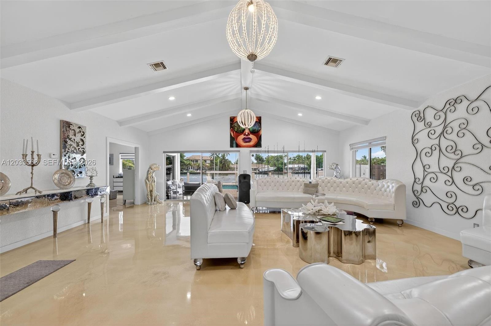 A spacious white living room features vaulted ceilings, glossy floors, and a waterfront view — 317 S Riverside Dr, Pompano Beach FL 33062, POMPANO BEACH, FL