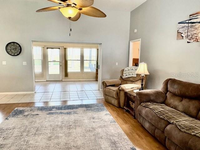 A living room features a ceiling fan, a recliner, a sofa, and a sliding glass door — 422 HARBOURVIEW DRIVE, HAINES CITY, FL