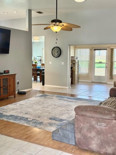 A living room with a ceiling fan, area rug, and an adjacent dining area — 422 HARBOURVIEW DRIVE, HAINES CITY, FL