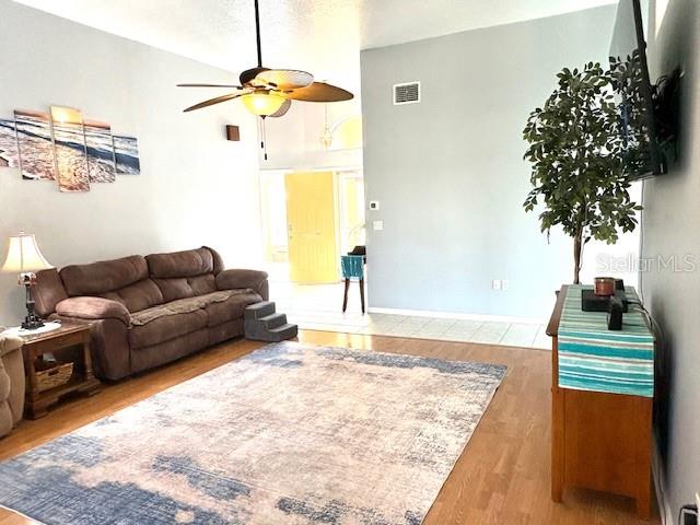 A living room features a brown sofa, a large area rug, and a ceiling fan — 422 HARBOURVIEW DRIVE, HAINES CITY, FL