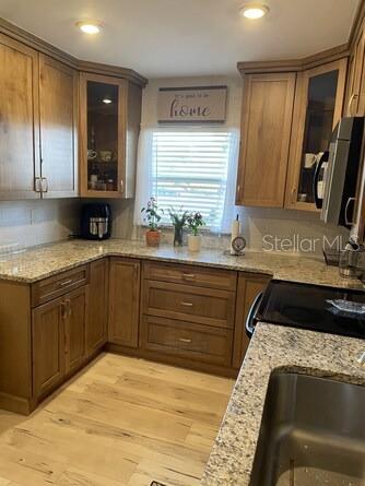 A kitchen with wood cabinets, granite countertops, and a window above the sink — 5103 29TH STREET W, BRADENTON, FL