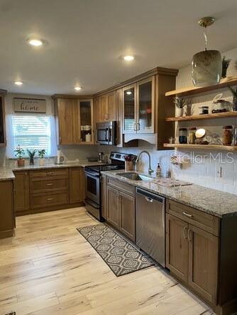 A kitchen with wood cabinets, granite countertops, stainless steel appliances, and open shelving — 5103 29TH STREET W, BRADENTON, FL