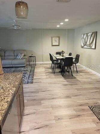 An open-concept living and dining area features light wood-look flooring and a neutral color palette — 5103 29TH STREET W, BRADENTON, FL