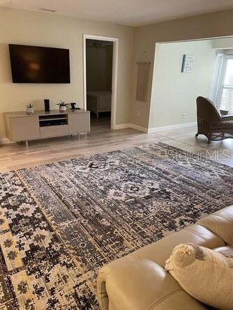 A living room features a large patterned area rug, a television, and a beige sofa — 5103 29TH STREET W, BRADENTON, FL