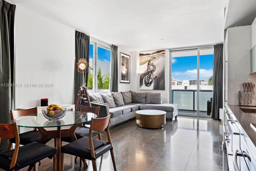 A modern living room features a grey sectional sofa, glass dining table, and balcony access — 220 21st St # 401, Miami Beach FL 33139, MIAMI BEACH, FL
