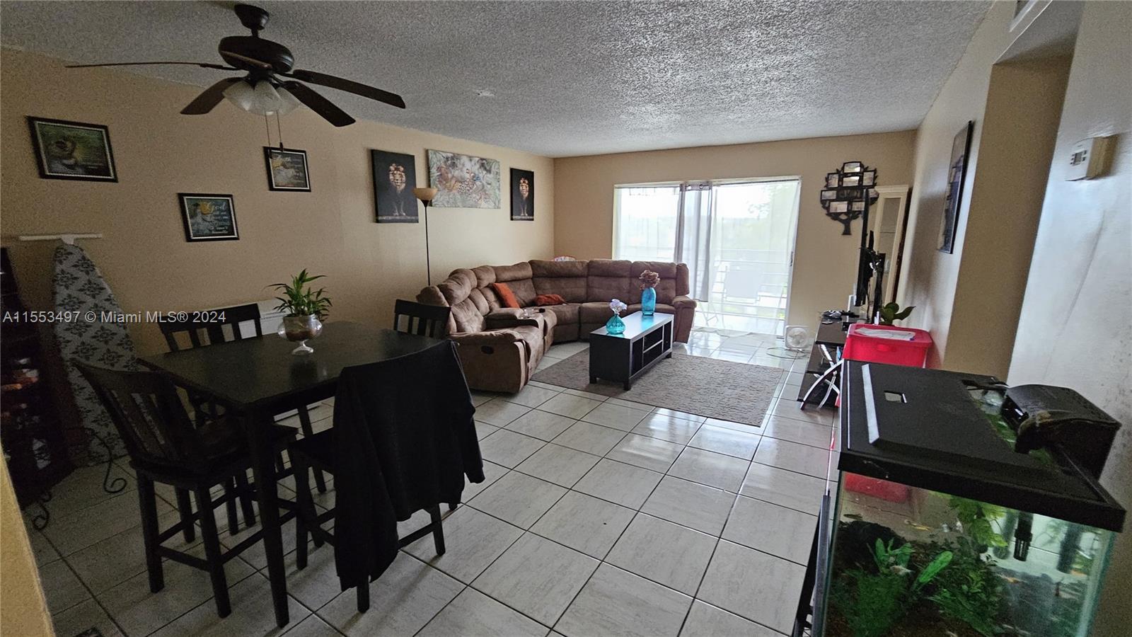 A living and dining area features tile flooring, a brown sectional sofa, and a fish tank — 2800 NW 56th Ave # A403, Lauderhill FL 33313, LAUDERHILL, FL