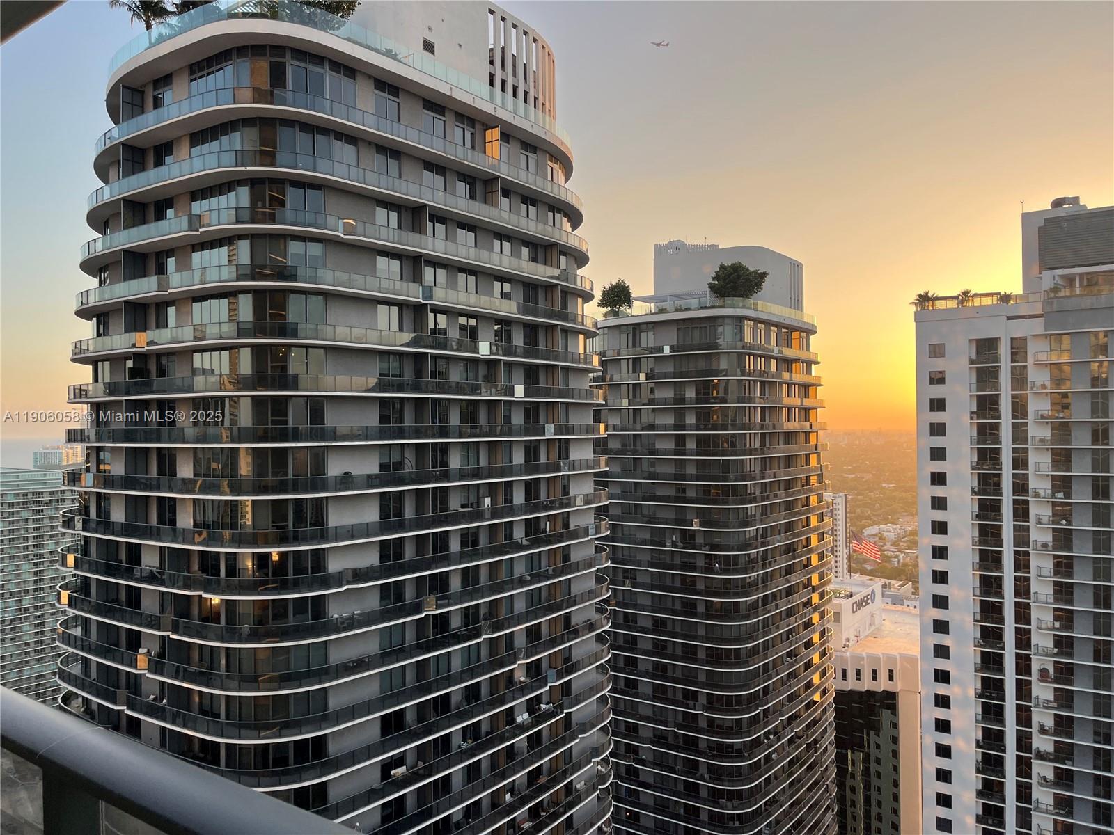 Three modern high-rise residential towers stand against a sunset sky — 801 S Miami Ave # 4309, Miami FL 33130, MIAMI, FL