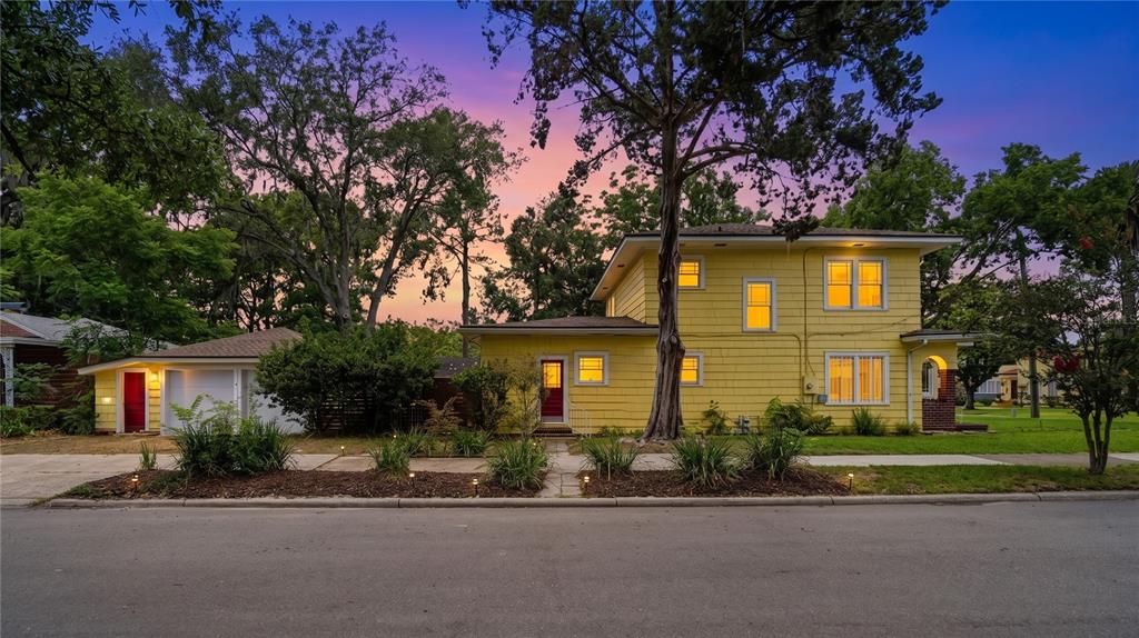 A two-story yellow house with a detached garage stands under a colorful sunset sky — 1544 TALBOT AVENUE, JACKSONVILLE, FL