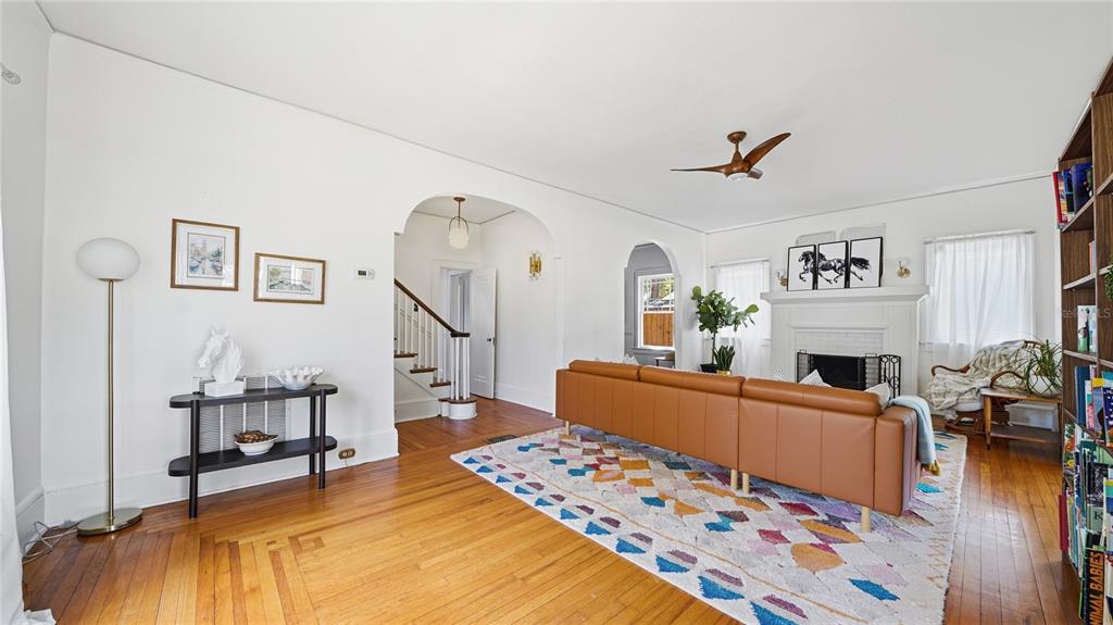A living room features hardwood floors, a tan leather sofa, a fireplace, and arched doorways — 1544 TALBOT AVENUE, JACKSONVILLE, FL