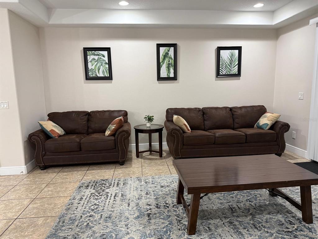A living room features two brown leather sofas, a coffee table, and three framed prints — 8106 ROSEVILLE ROAD, DAVENPORT, FL