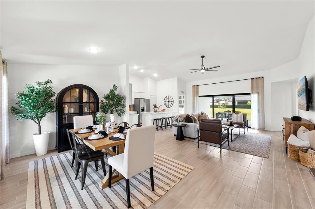 An open-concept living and dining area with tile flooring, neutral walls, and a kitchen island — 3445 W DITTANY DRIVE, CITRUS SPRINGS, FL