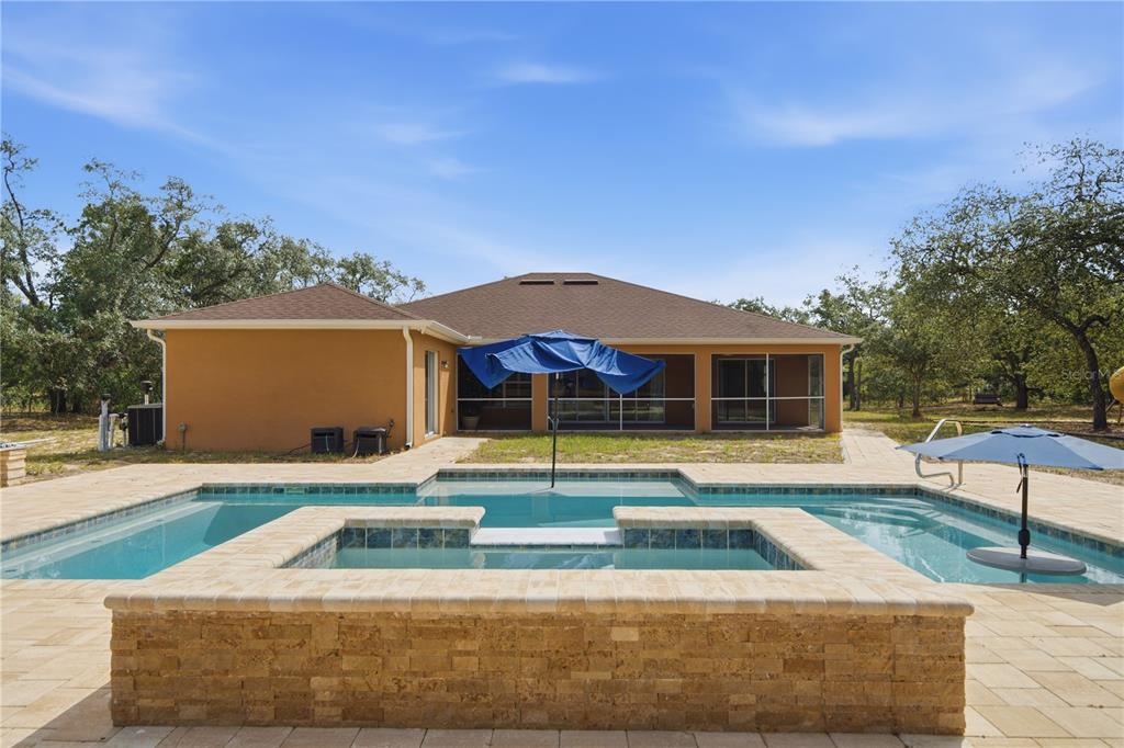 A single-story house with a tan stucco exterior, a three-car garage, and a front lawn — 13403 LELANI DRIVE, WEEKI WACHEE, FL