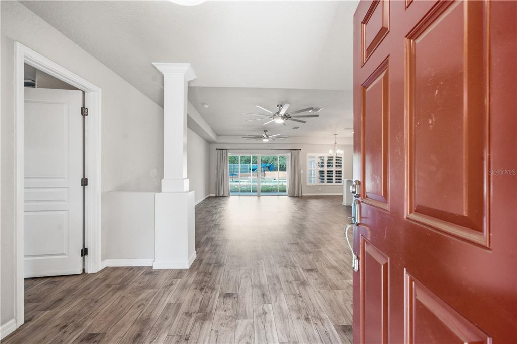 A rectangular swimming pool with a built-in spa sits on a large stone patio — 13403 LELANI DRIVE, WEEKI WACHEE, FL