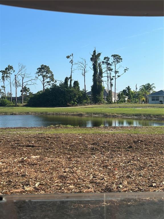 A view of a pond and trees from a dirt lot under a clear sky — 37 TEE VIEW ROAD, ROTONDA WEST, FL