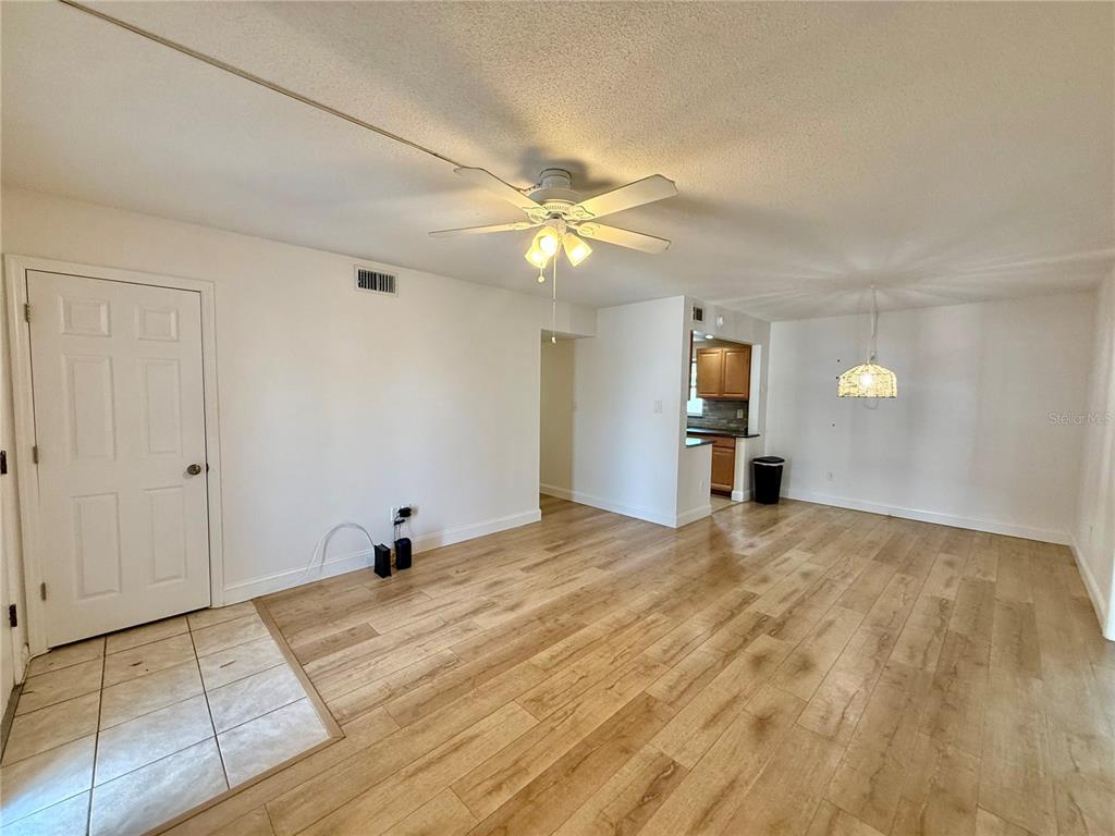 An open-concept living and dining area features light wood-look flooring and a ceiling fan — 1960 UNION STREET UNIT 41, CLEARWATER, FL