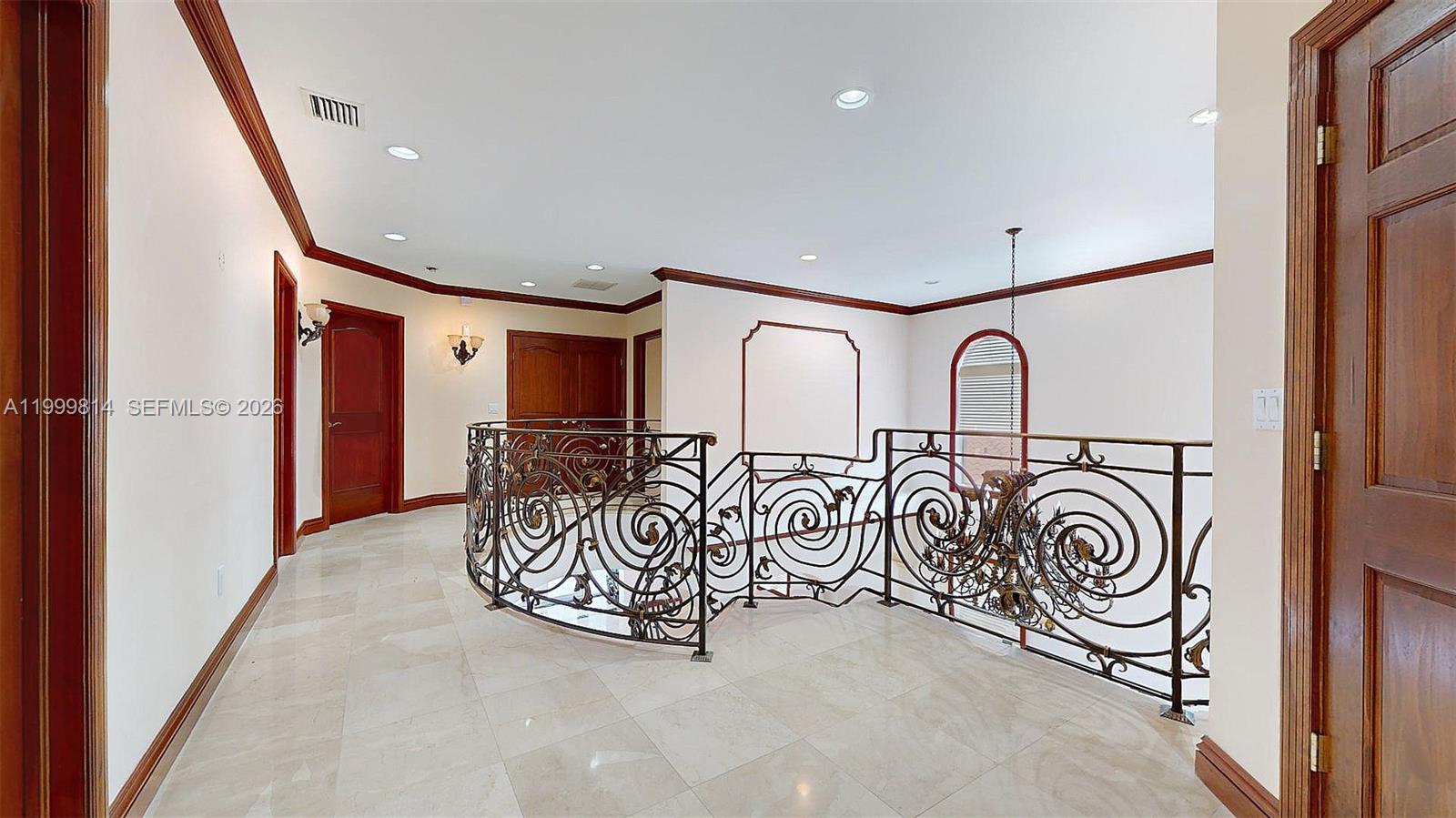 A second-floor landing features marble flooring, decorative iron railings, and dark wood trim — 1131 Stillwater Dr, Miami Beach FL 33141, MIAMI BEACH, FL