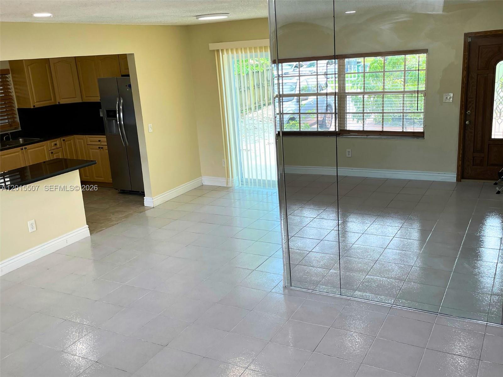 A tiled dining area features a mirrored wall, sliding glass doors, and an adjacent kitchen — 22430 SW 113th Ct, Miami FL 33170, MIAMI, FL