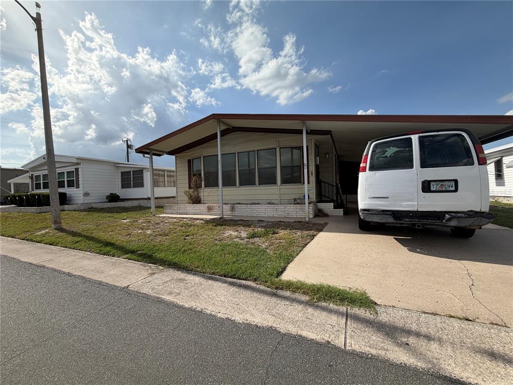 An enclosed porch features white paneled walls, brown carpeting, a ceiling fan, and large windows — 1007 CASSANDRA LANE, LAKELAND, FL