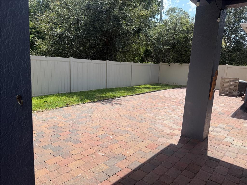 A single-story house with a brick driveway, front porch, and American flag at dusk — 1211 TURNBRIDGE PLACE, OVIEDO, FL