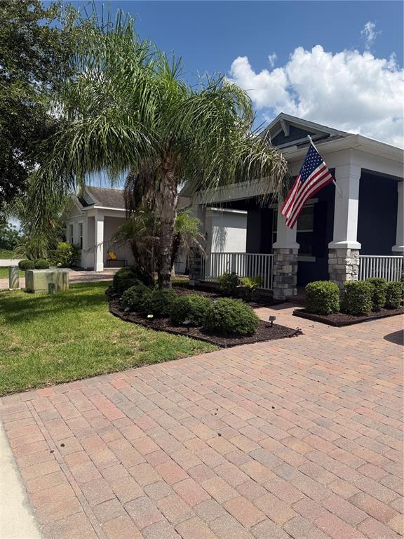 A modern kitchen features white cabinetry, a central island with bar stools, and dark flooring — 1211 TURNBRIDGE PLACE, OVIEDO, FL