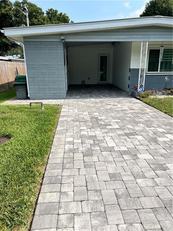 A gray brick house features a covered carport and a newly installed paver driveway — 1950 Cortez Boulevard, Fort Pierce FL 34982, FORT PIERCE, FL