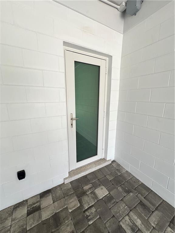 A white door with a glass panel is set in a white concrete block wall — 1950 Cortez Boulevard, Fort Pierce FL 34982, FORT PIERCE, FL