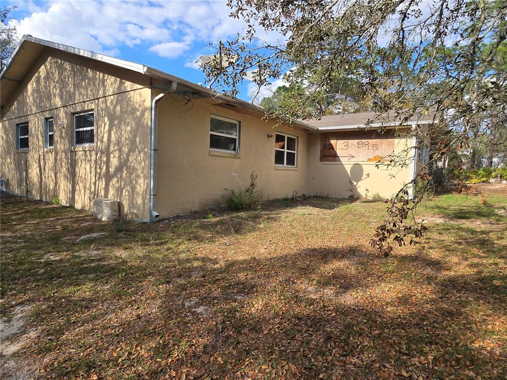 The exterior of a house features a screened-in porch and an adjacent wooden deck — 4711 S HAWKDALE POINT, LECANTO, FL