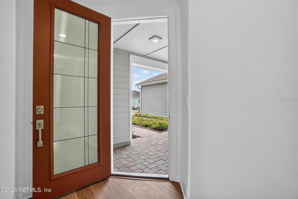 An open front door reveals a paved entryway and a view of a neighboring house — 436 JUBILEE CIRCLE, YULEE, FL