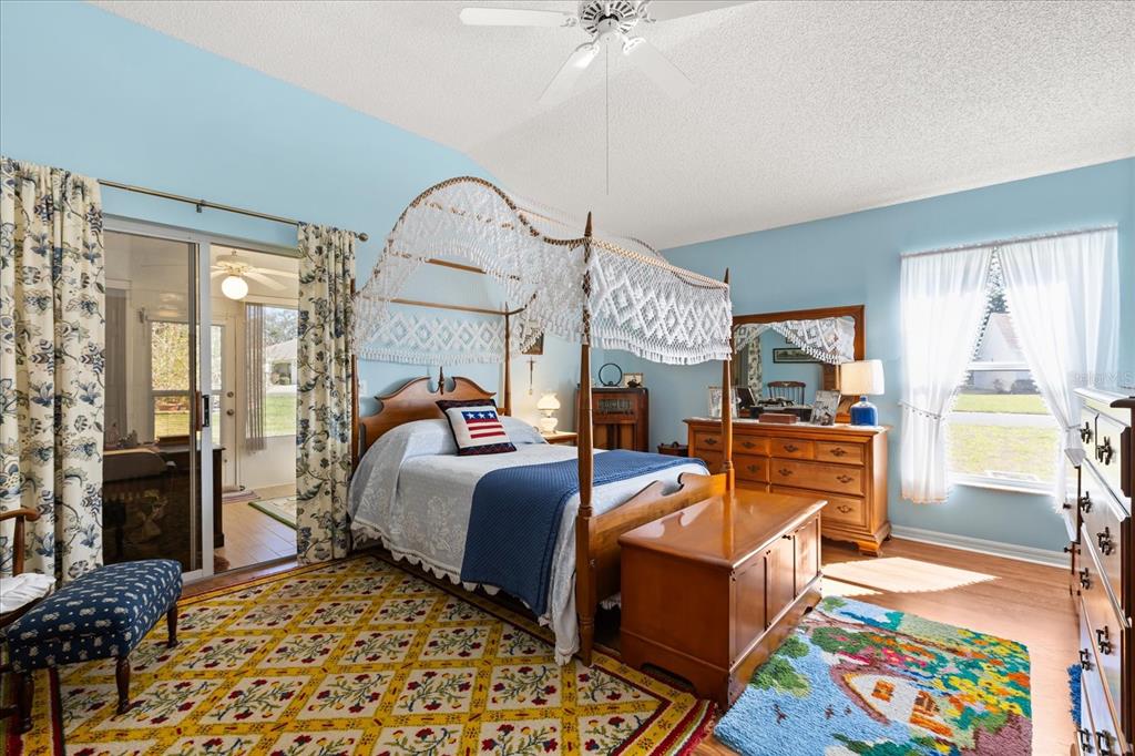 A bedroom with light blue walls, a four-poster canopy bed, and a patterned area rug — 1301 FONTANA COURT, THE VILLAGES, FL