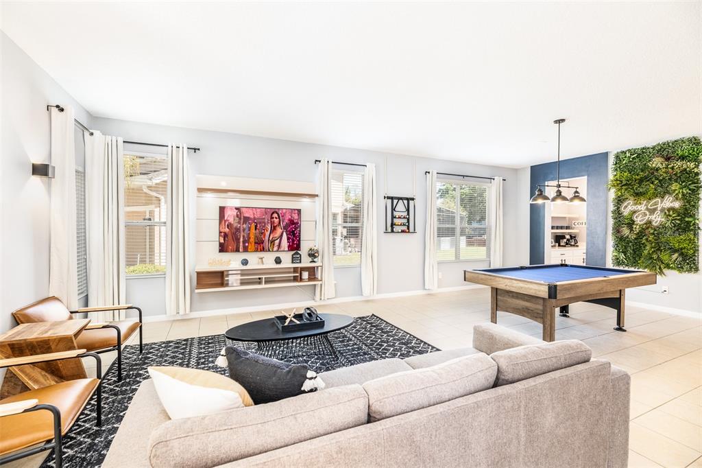 A living room features a pool table, a television console, and a green wall accent — 161 LAS FUENTES DRIVE, KISSIMMEE, FL