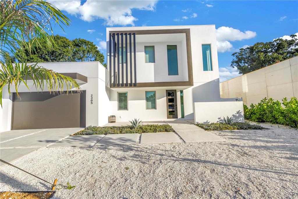 A modern two-story white house features a flat roof, dark accents, and a gravel driveway — 2305 TEMPLE STREET, SARASOTA, FL