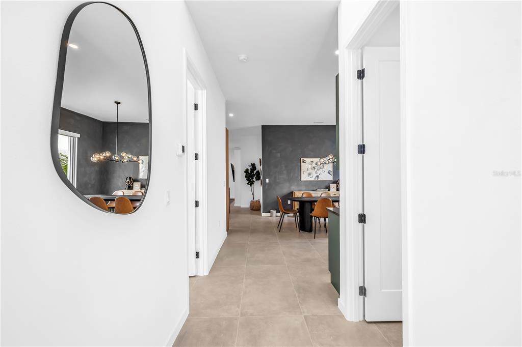 A hallway with light tile flooring leads to a dining area with dark accent walls — 2305 TEMPLE STREET, SARASOTA, FL
