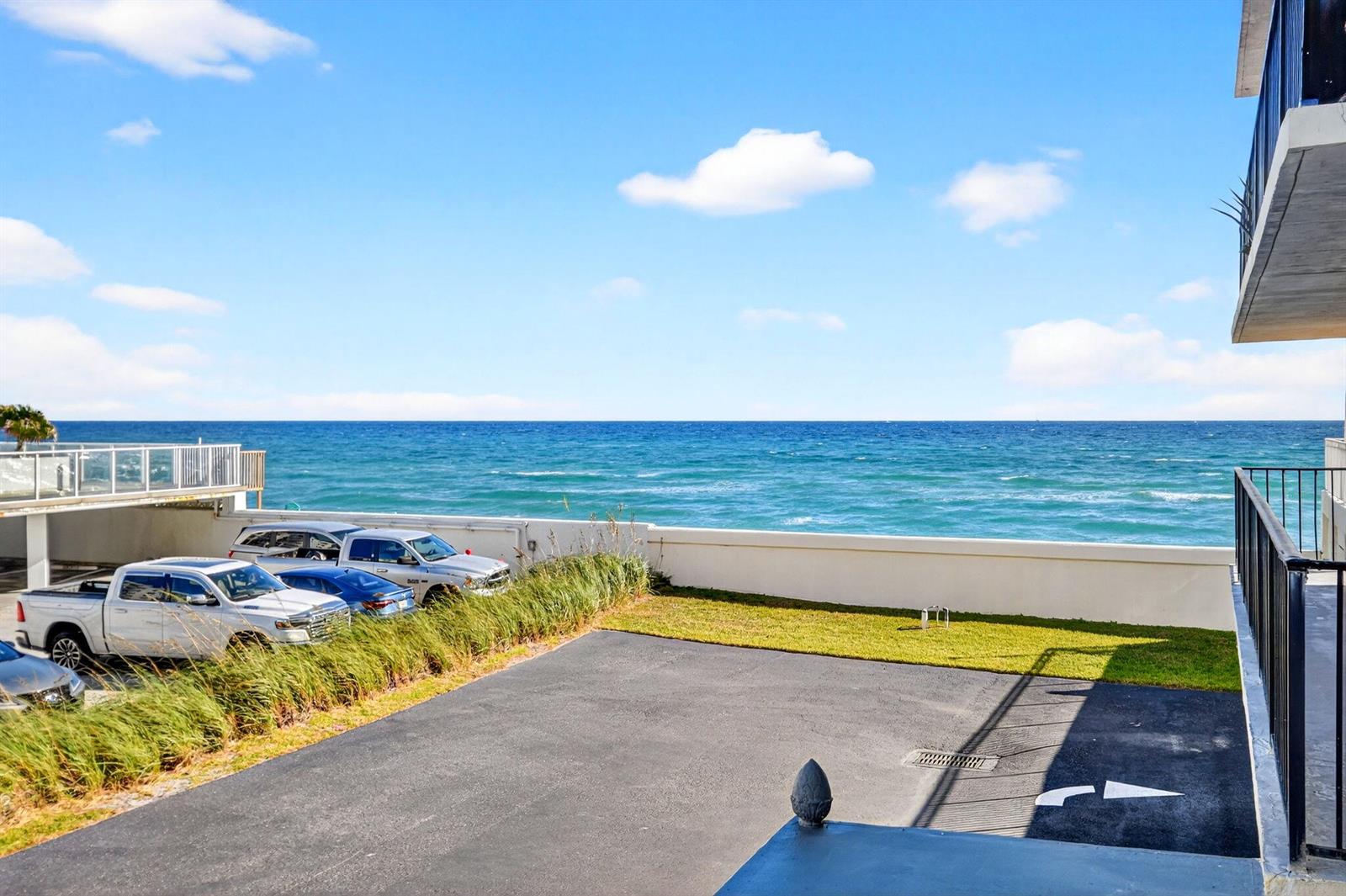An outdoor parking area overlooks the ocean from a building with a balcony — 3456 S Ocean Boulevard # 1040, Palm Beach FL 33480, PALM BEACH, FL