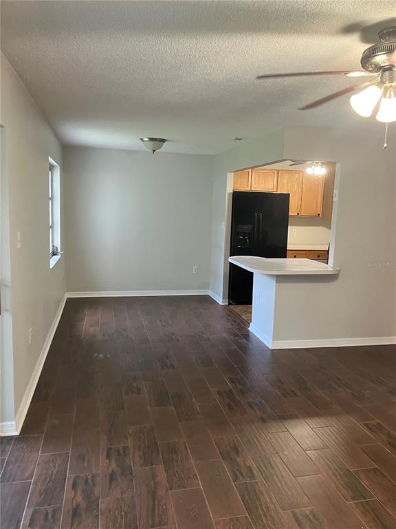 An open-concept dining area features dark wood-look tile flooring and a breakfast bar — 337 S MCMULLEN BOOTH ROAD UNIT 157, CLEARWATER, FL