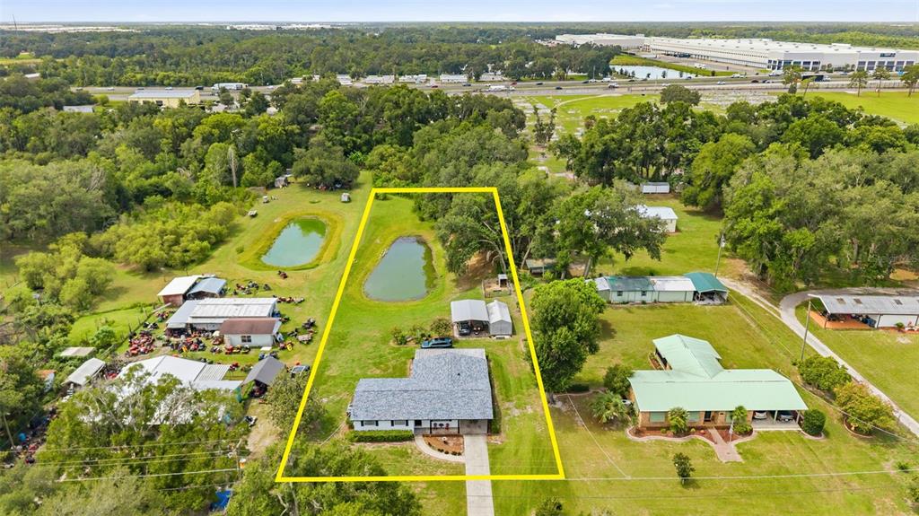 An aerial view shows a house with a pond on a large, grassy lot — 3825 SWINDELL ROAD, PLANT CITY, FL