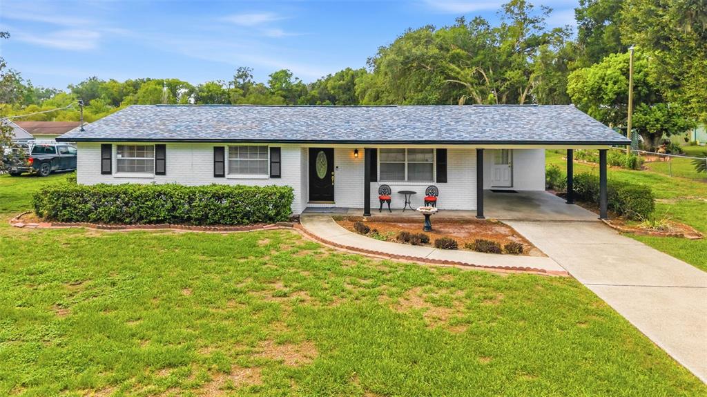A single-story white brick house with a blue shingled roof and an attached carport — 3825 SWINDELL ROAD, PLANT CITY, FL