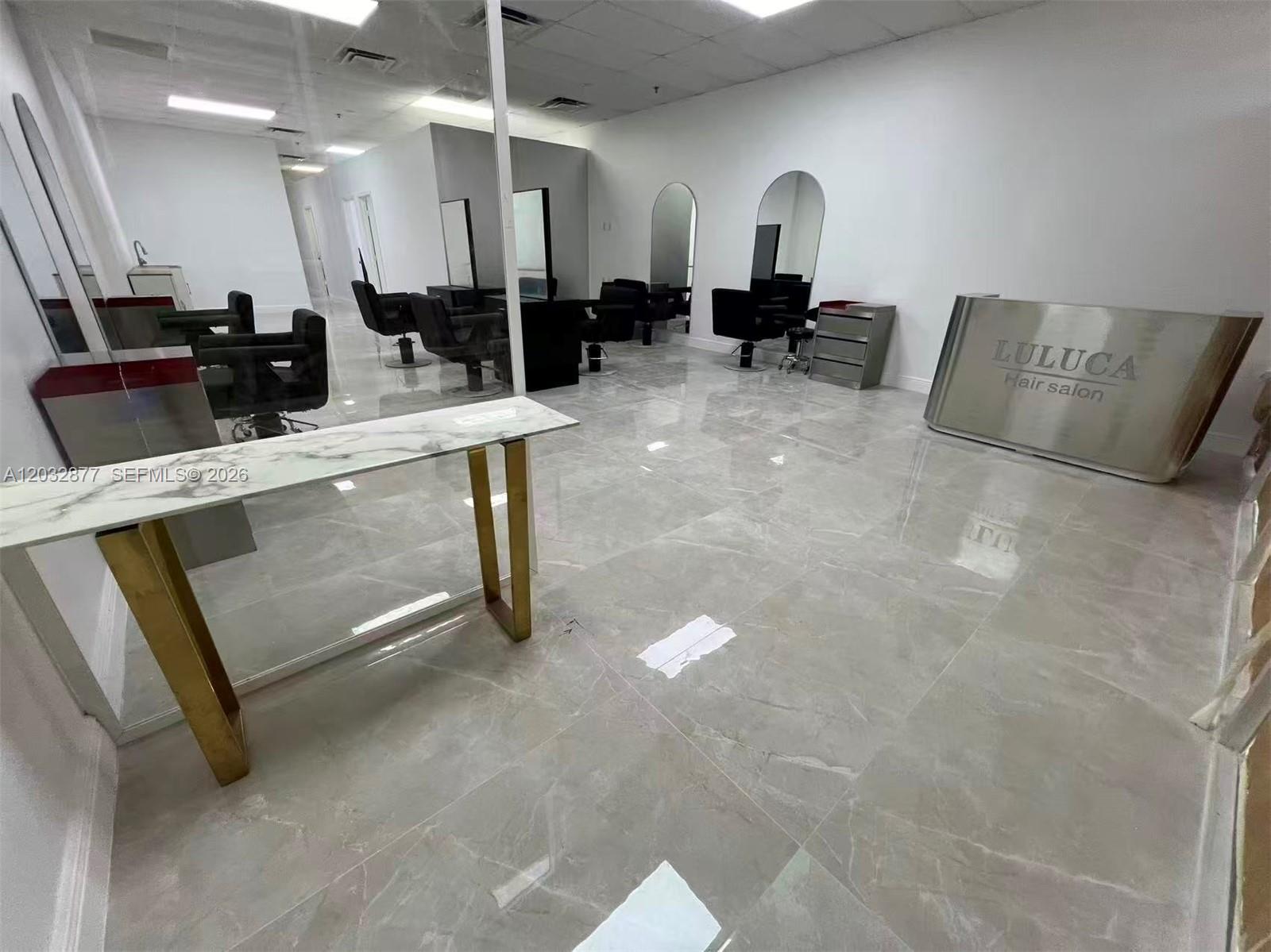 A modern hair salon features white walls, gray tiled floors, styling stations, and a reception desk — Stirling Rd, Davie FL 33314, DAVIE, FL
