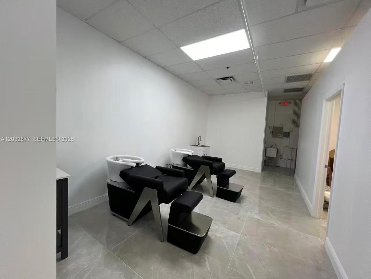 A salon room features two black shampoo stations on a light-colored tiled floor — Stirling Rd, Davie FL 33314, DAVIE, FL
