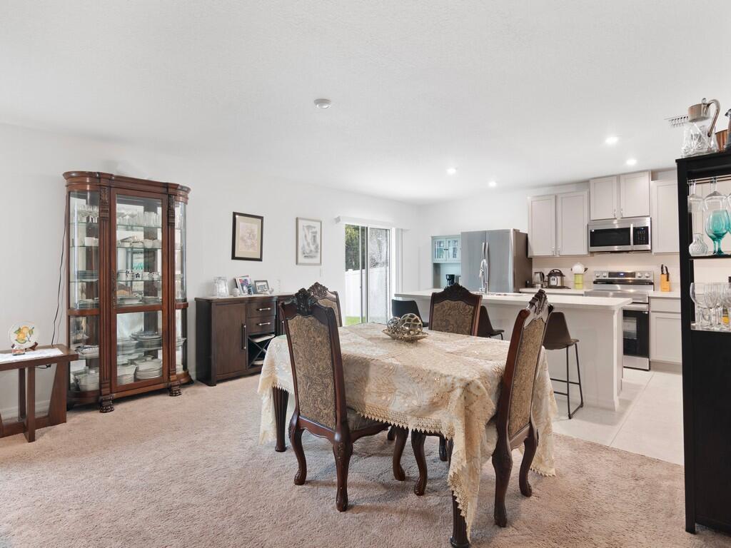 A dining area with a table and chairs sits adjacent to an open-concept kitchen — 7976 105th Avenue, Vero Beach FL 32967, VERO BEACH, FL