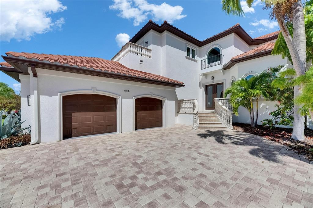 A two-story house with a tiled roof, two garage doors, and a paved driveway — 6418 BRIGHT BAY COURT, APOLLO BEACH, FL