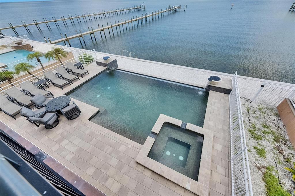 An elevated view of a waterfront swimming pool and hot tub with a stone patio — 6418 BRIGHT BAY COURT, APOLLO BEACH, FL