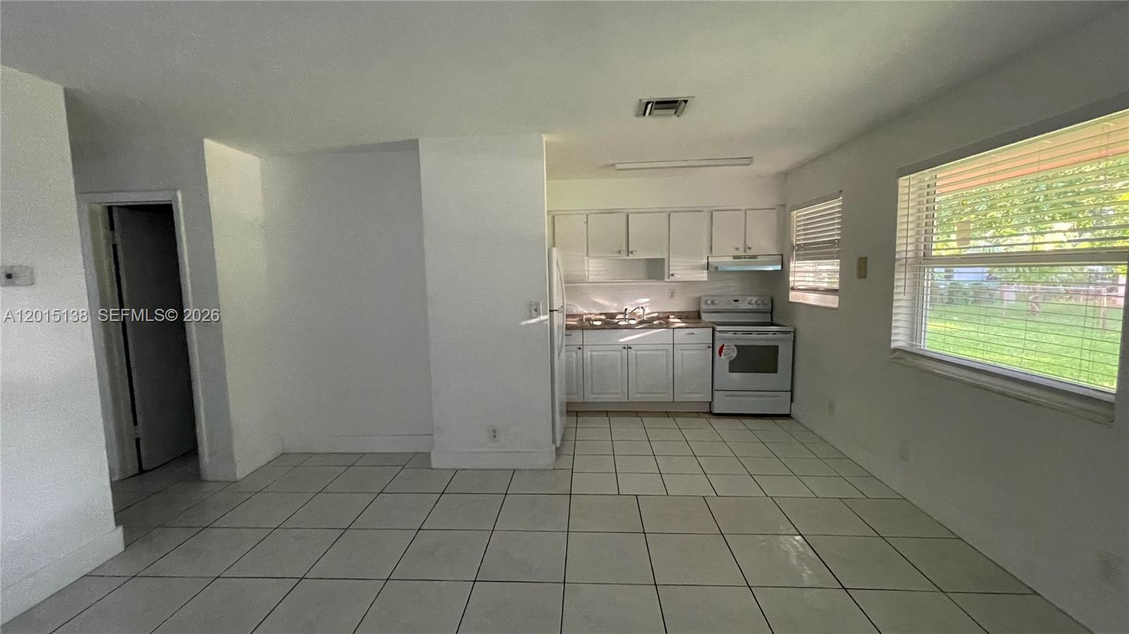 A kitchen with white cabinets, white appliances, and light-colored tile flooring — 5200 NW 16th St, Lauderhill FL 33313, LAUDERHILL, FL