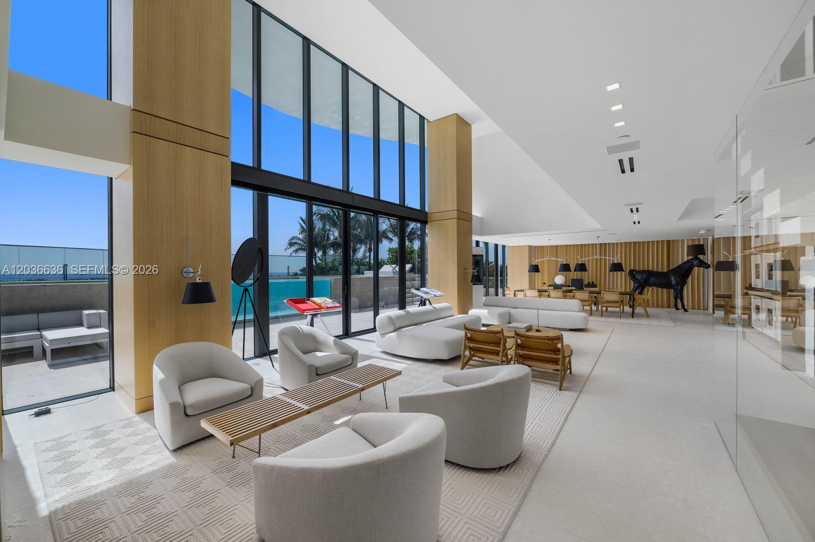 A spacious, modern living area features floor-to-ceiling windows, light wood columns, and a private terrace — 19575 Collins Ave # 3, Sunny Isles Beach FL 33160, SUNNY ISLES BEACH, FL