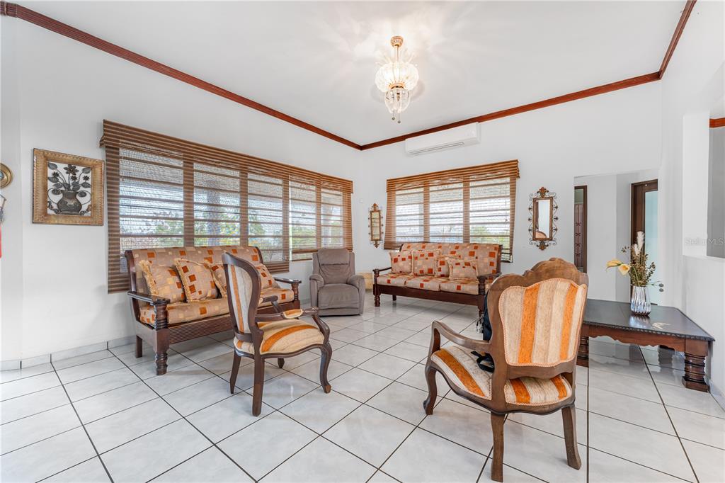 A living room features tile floors, wooden furniture, striped chairs, and window blinds — SR 100 k2h7 int Guanajibo PLAN BONITO ST, CABO ROJO, PR