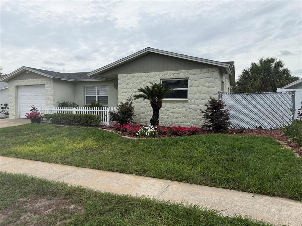 A single-story house with a stone facade, a white picket fence, and a front lawn — 6310 DIAMOND DRIVE DRIVE, NEW PORT RICHEY, FL