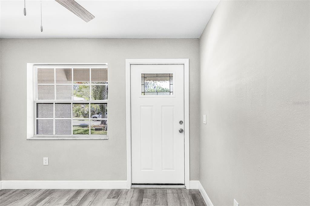 An interior view of an entryway featuring a white front door, window, and wood flooring — 2648 MICHIGAN AVENUE, FORT MYERS, FL