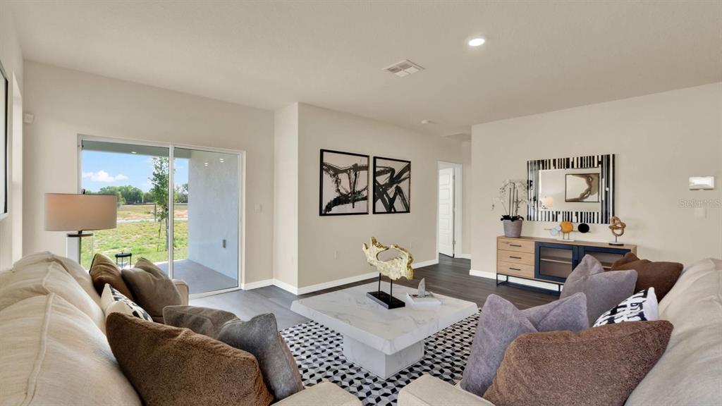 A living room features a sectional sofa, a marble coffee table, and a sliding glass door — 4415 BLACKWELL AVENUE, LAKE WALES, FL